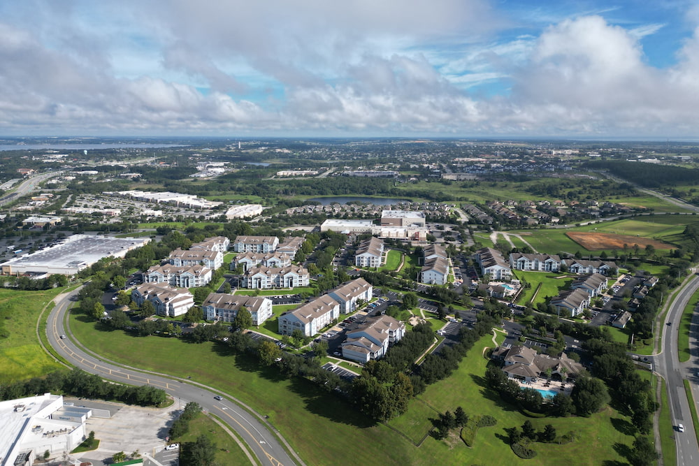 A bird's eye view of the cityscape of Clermont, Florida under a cloudy blue sky